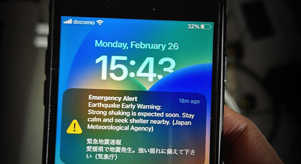 Smartphone com notificação de alerta de terremoto em japonês e inglês